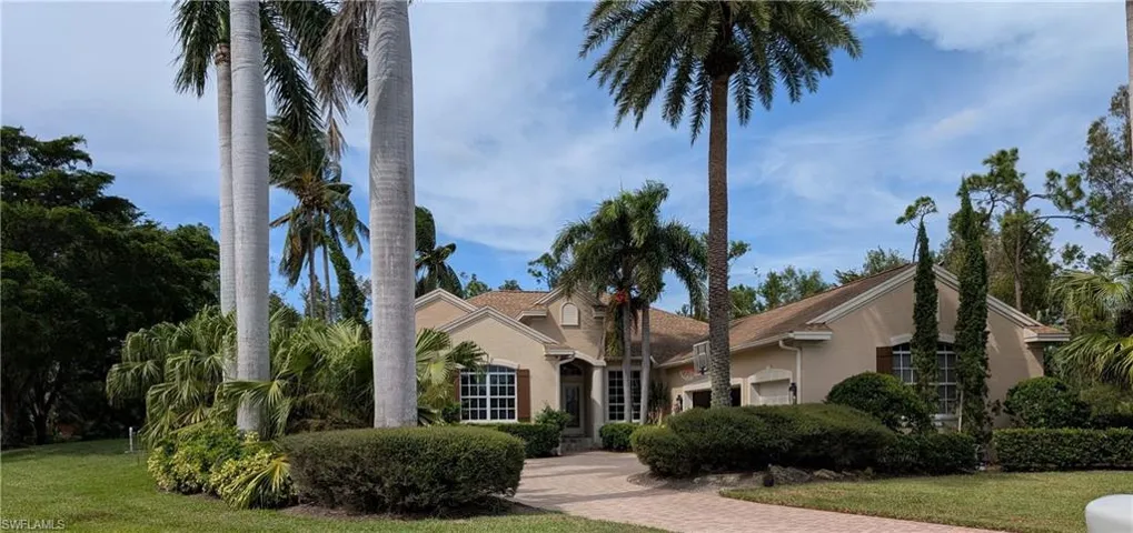 View of front facade with tall Royal palms