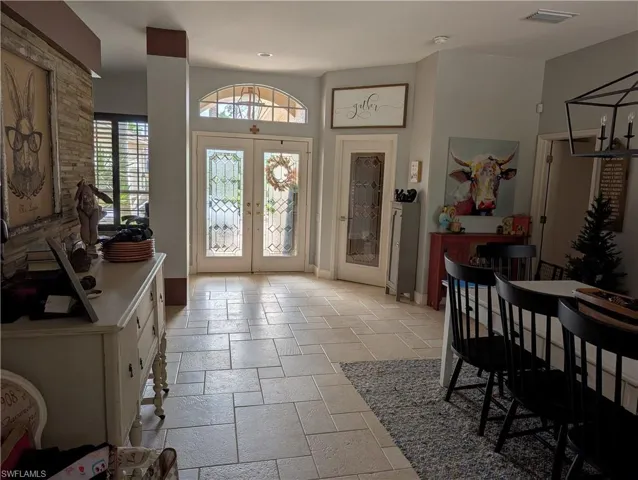 Foyer entrance featuring french doors and a chandelier