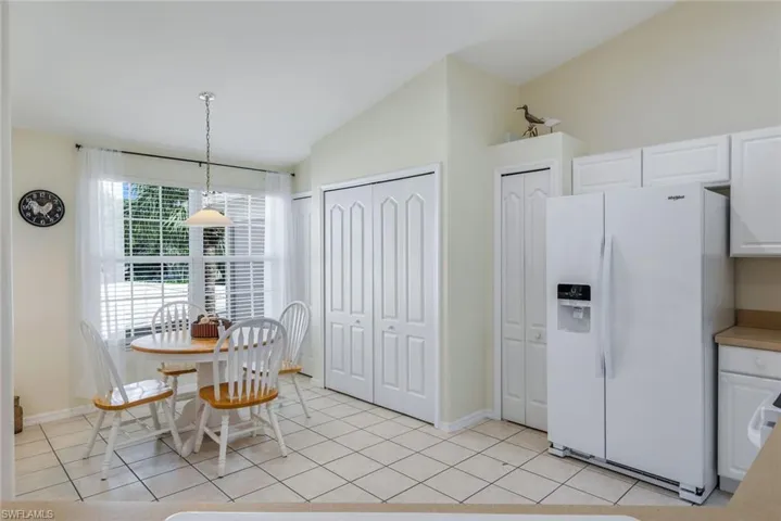 Dining space featuring vaulted ceiling and light tile patterned flooring