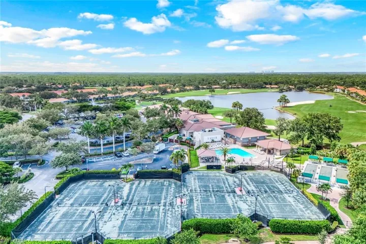 Aerial perspective of suburban area featuring a local golf course and a large body of water