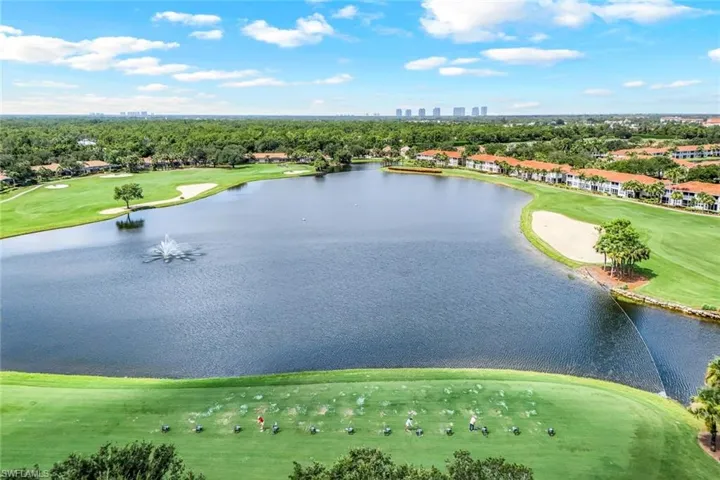 Aerial view of a golf club, city skyline, and a nearby body of water