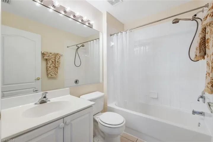 Full bathroom with shower / tub combo, vanity, and tile patterned floors