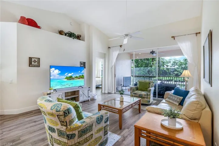 Living area featuring wood finished floors, ceiling fan, and high vaulted ceiling