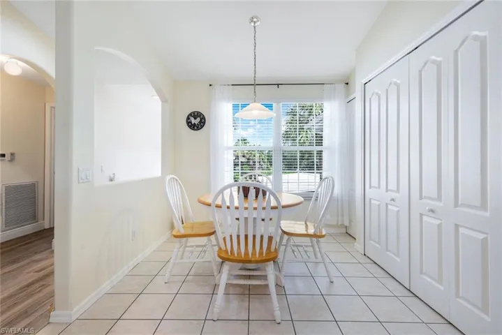 Dining space with arched walkways and light tile patterned floors
