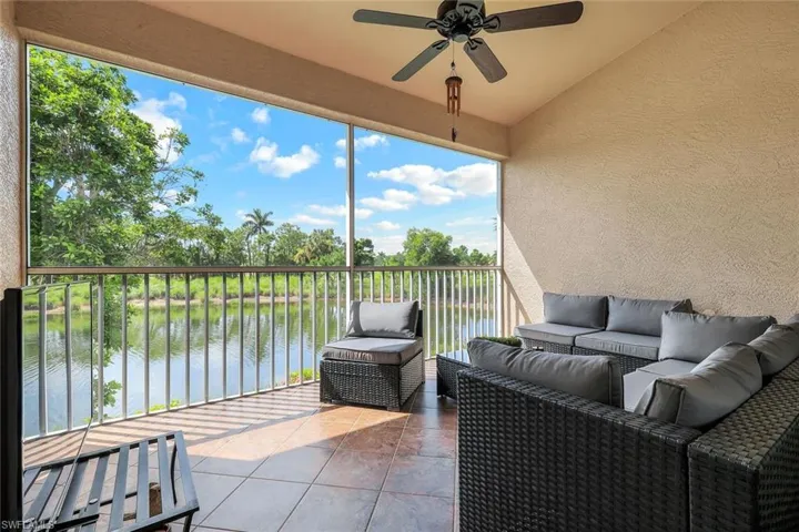 Sunroom / solarium with a water view, an outdoor hangout area, ceiling fan, vaulted ceiling, and view of scattered trees