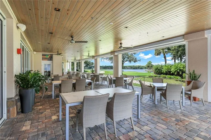 View of patio with outdoor dining space, a ceiling fan, a water view, and view of golf course