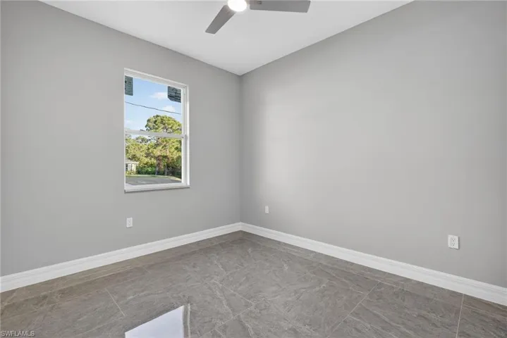Empty room with baseboards and a ceiling fan
