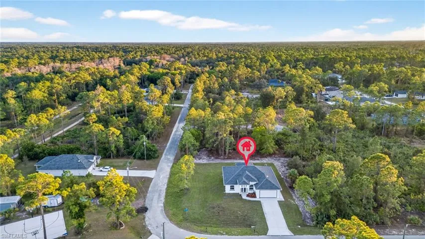 Aerial view of property and surrounding area with a heavily wooded area