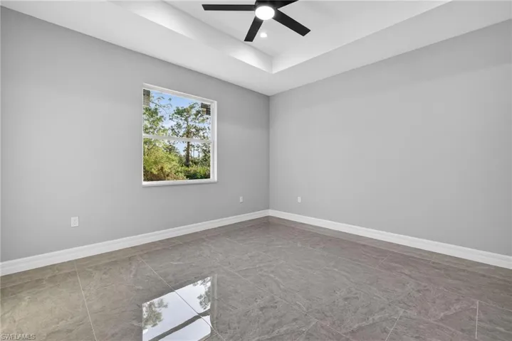 Spare room featuring a tray ceiling, ceiling fan, and recessed lighting