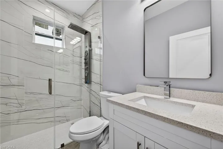 Full bathroom with a marble finish shower and vanity