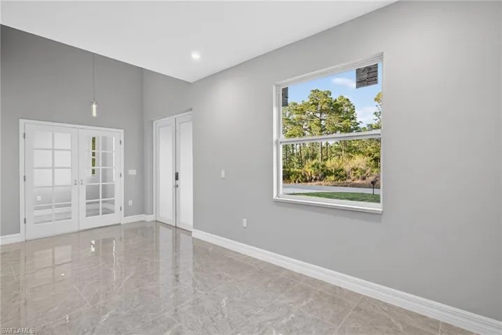 Unfurnished room with french doors, light marble finish floors, and recessed lighting