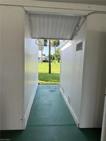 Outdoor hallway leading to the back of the home through the carport