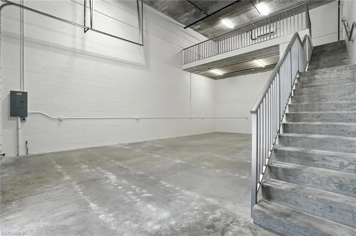 Garage featuring electric panel and concrete block wall