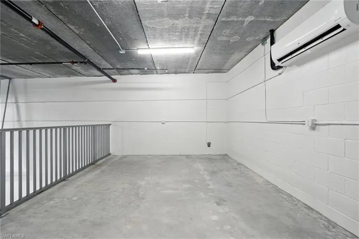 Garage with a wall mounted air conditioner and concrete block wall