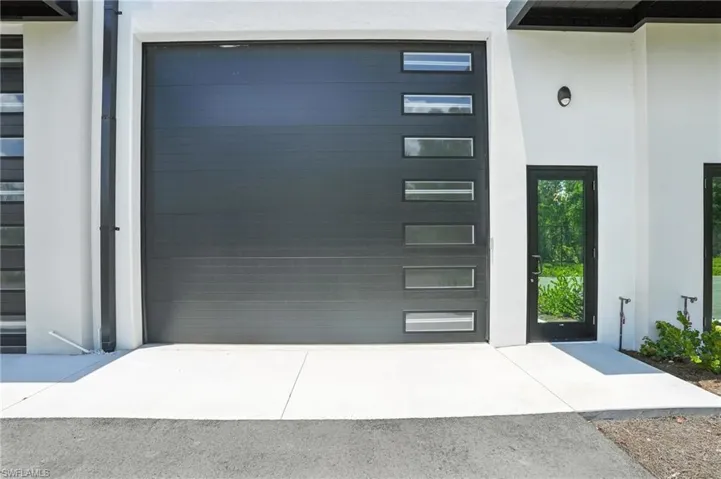 View of exterior entry with stucco siding and a garage