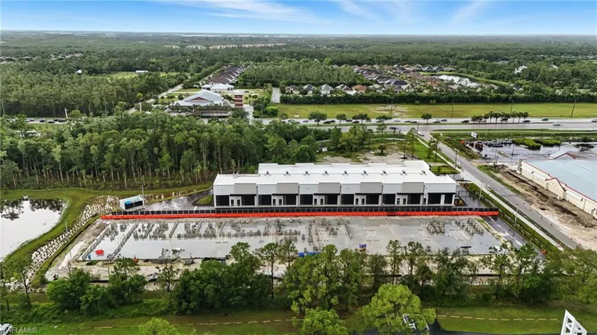 Drone / aerial view of a heavily wooded area and a nearby body of water