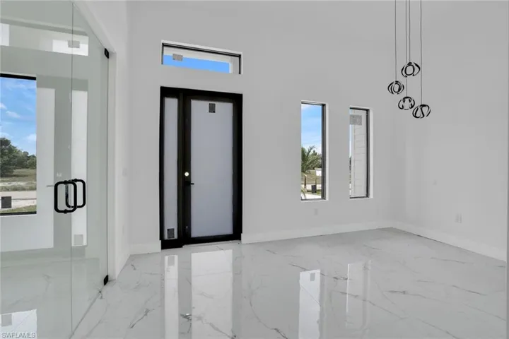 Foyer with marble tiled flooring and a towering ceiling