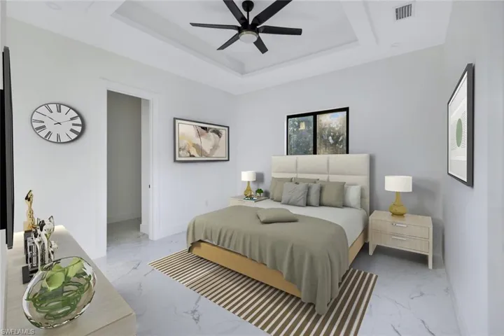 Bedroom featuring light marble finish flooring, a raised ceiling, and a ceiling fan
