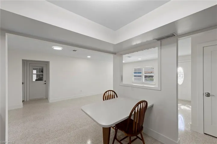 Dining space featuring baseboards and dark aggregate flooring