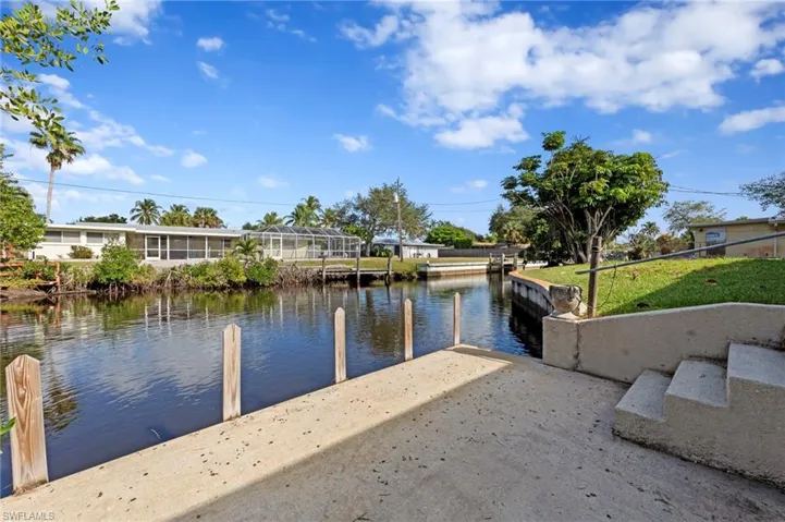 Dock with a water view and a lawn