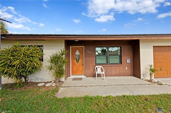 Doorway to property featuring a garage and stucco siding