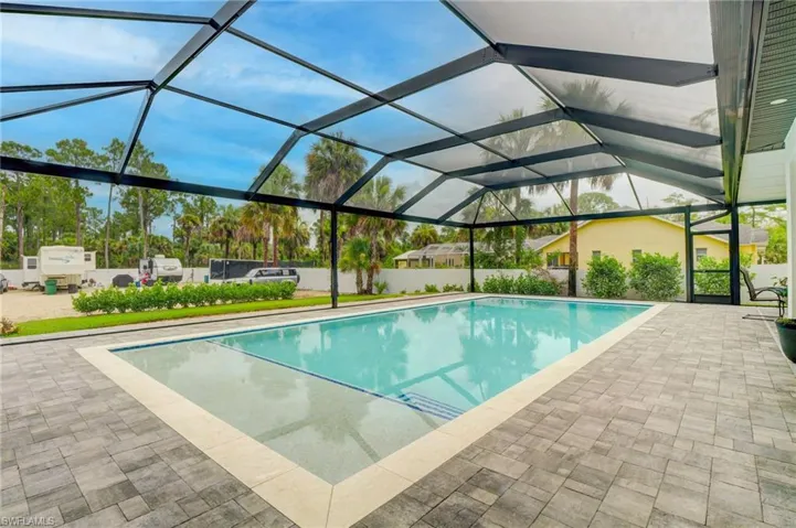 View of swimming pool featuring a lanai and a patio area