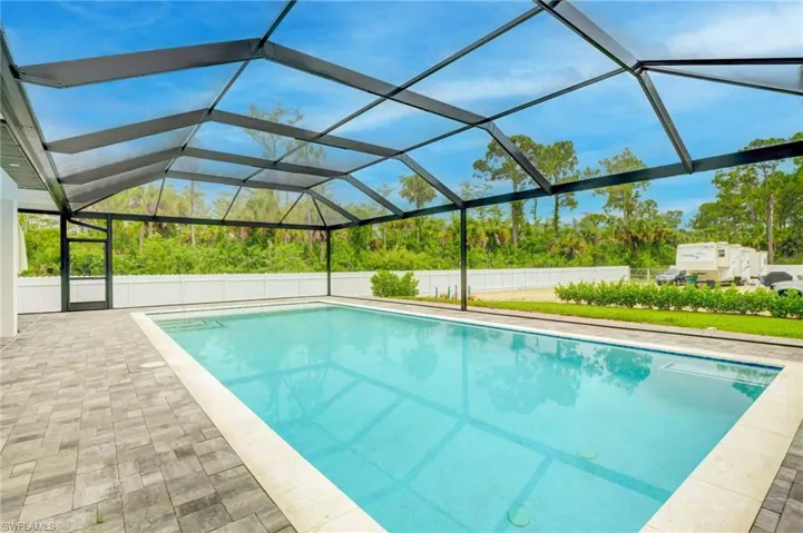 View of pool featuring a lanai and a patio area and clearview screened enclosure