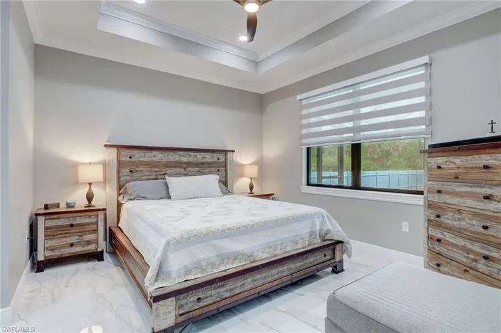 Bedroom featuring ornamental molding, ceiling fan, and a raised ceiling