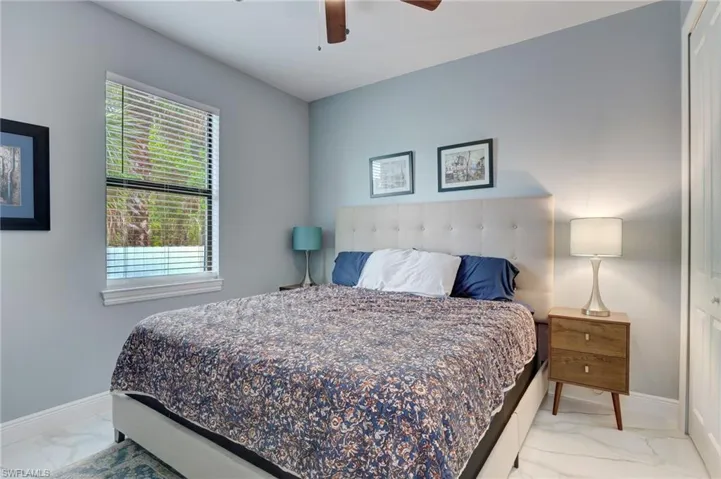 Tiled bedroom featuring ceiling fan