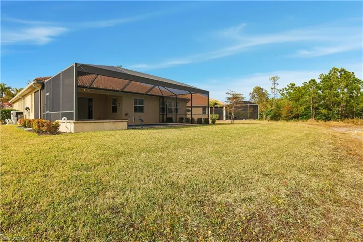 Rear view of property featuring a sunroom, glass enclosure, a yard, and a pool
