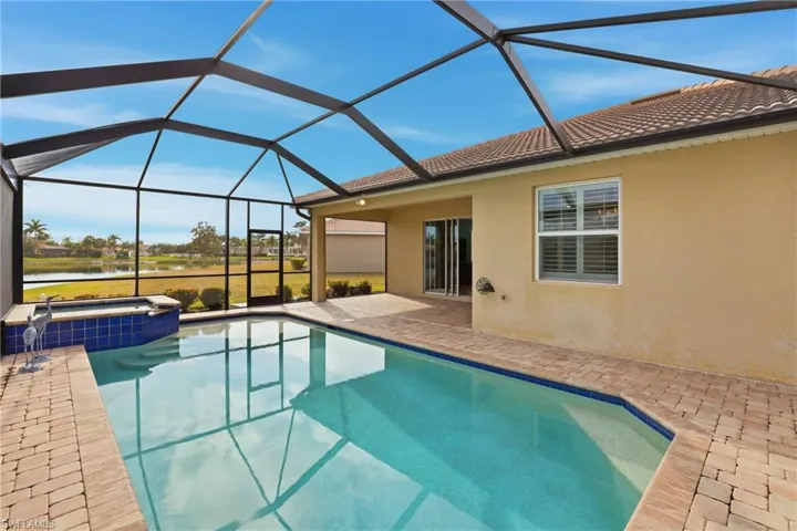 Integrated pool / spa featuring a sunroom, a patio area, a lanai, and a water view