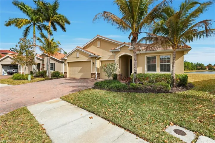 Mediterranean / spanish-style house featuring a garage, driveway, stucco siding, a tile roof, and a front yard
