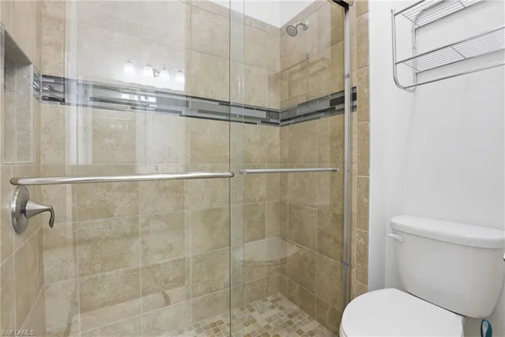 Bathroom featuring toilet and a shower stall