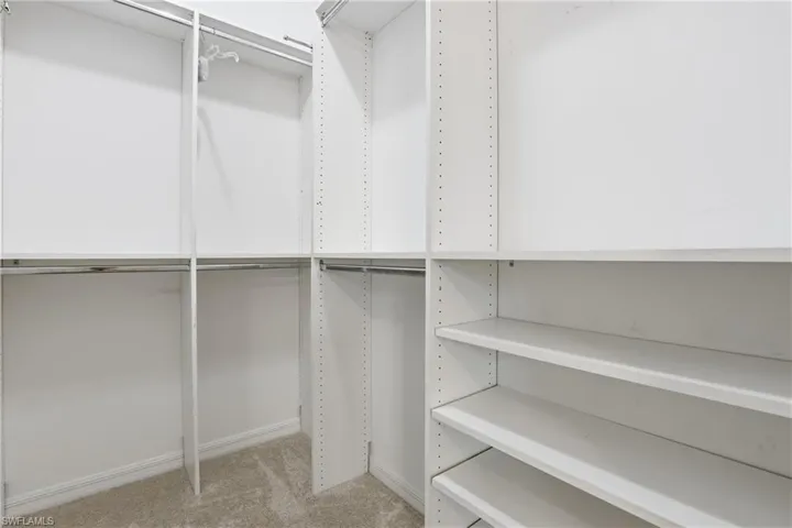 Guest room walk in closet with light carpet