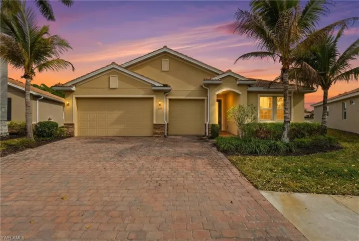 View of front of property with stucco siding, driveway, and an attached garage