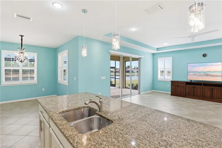 Kitchen with a chandelier, light tile patterned floors, and light stone countertops
