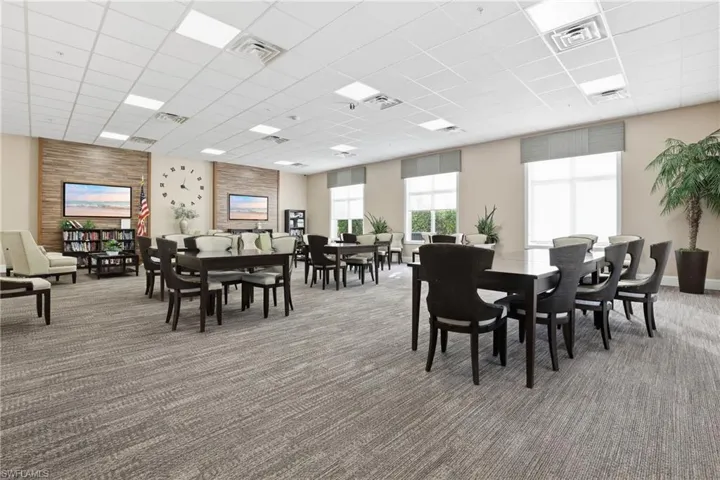 Dining space with a drop ceiling and light colored carpet