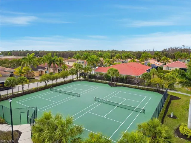 View of tennis court with a residential view