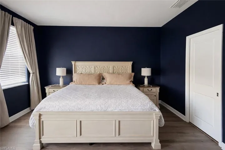Bedroom featuring baseboards and dark wood-style floors