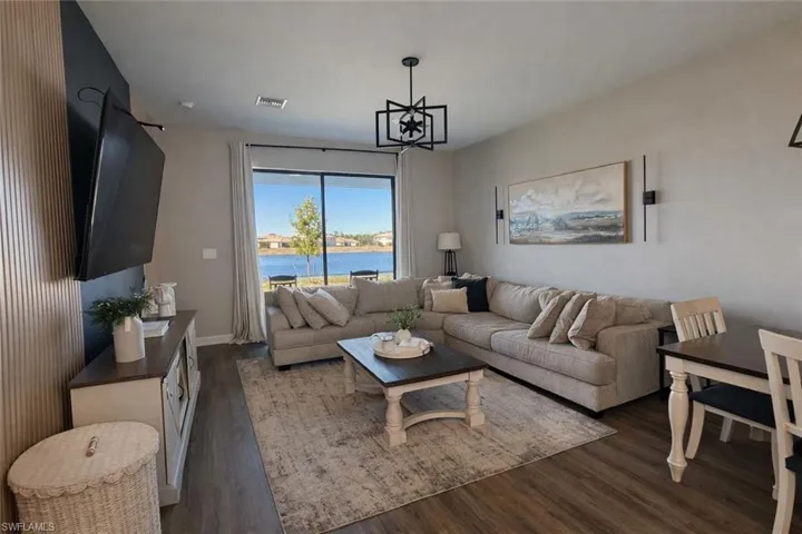 Living area with dark wood-style floors and suspended lighting