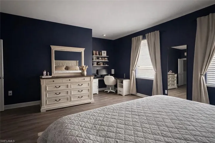 Bedroom featuring dark wood finished floors and an office area