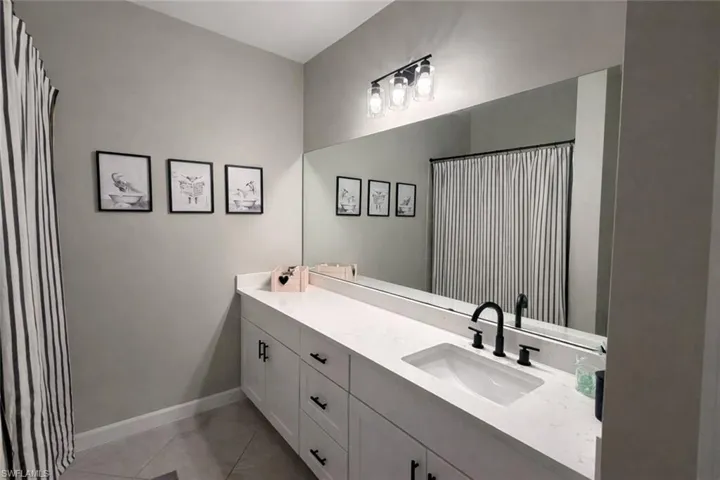 Bathroom featuring vanity, a shower with shower curtain, and light tile patterned floors