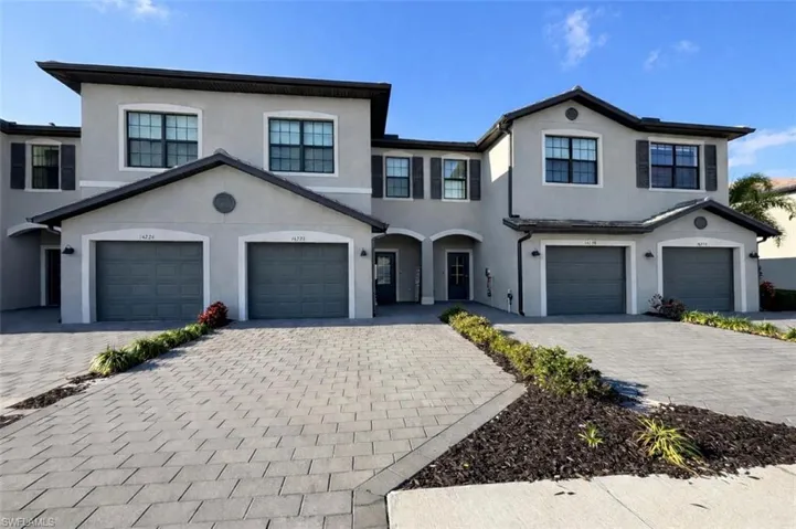 View of front of property featuring driveway, stucco siding, and a garage