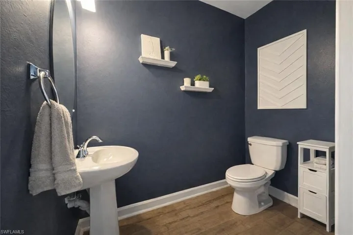 Half bath with toilet and dark wood-style floors