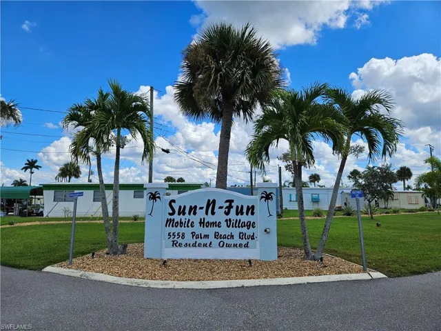 Community / neighborhood sign featuring a yard
