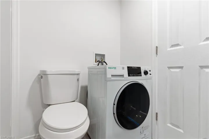 Bathroom with washer / clothes dryer and toilet