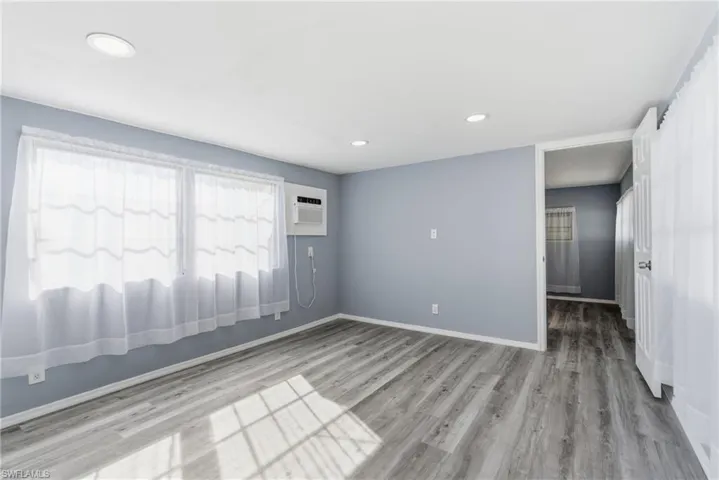 Spare room featuring light wood-style flooring, recessed lighting, and a wall mounted air conditioner