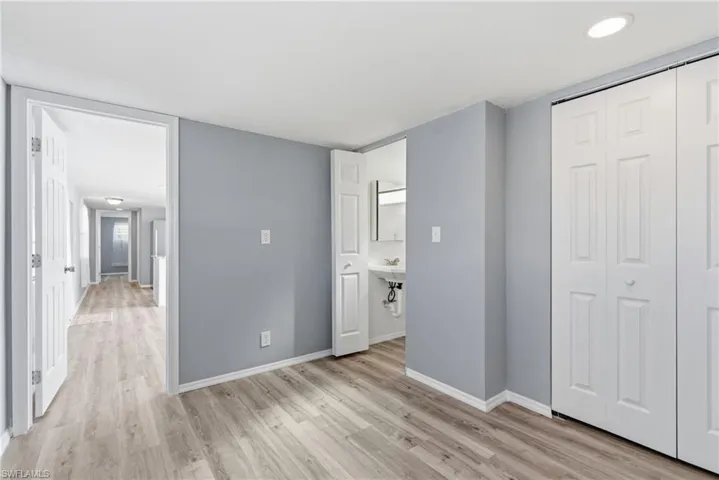 Primary bedroom with half bathroom and a closet