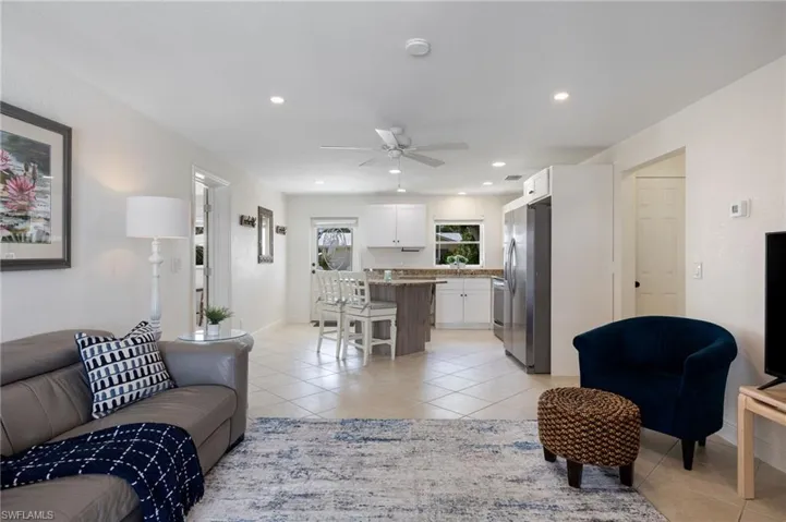 Living room with light tile patterned floors, ceiling fan, and recessed lighting