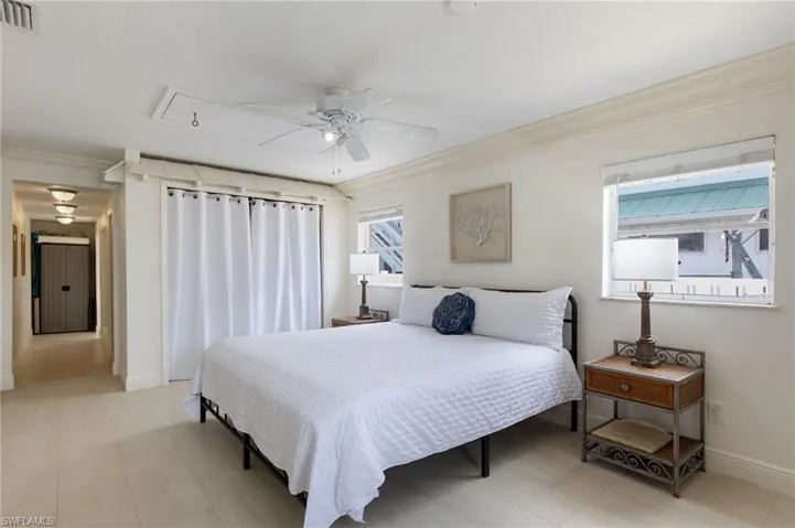 Bedroom with attic access, crown molding, and a ceiling fan